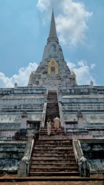 Wat Phu Khao Thong chedi in Ayutthaya, Thailand. White pagoda, couple men and women on a trip to Ayutthaya visit the white pagoda temple