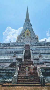 Wat Phu Khao Thong chedi in Ayutthaya, Thailand. White pagoda, couple men and women on a trip to Ayutthaya visit the white pagoda temple