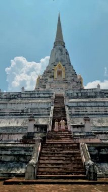Wat Phu Khao Thong chedi in Ayutthaya, Thailand. White pagoda, couple men and women on a trip to Ayutthaya visit the white pagoda temple