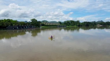 A couple of men and women in kayak on the River Kwai in Thailand. men and women peddling in a kayak on the river in Thailand