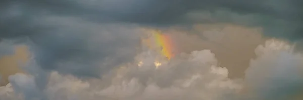 Rainbow in clouds during a storm. part of a rainbow in dark clouds during a monsoon storm in Thailand