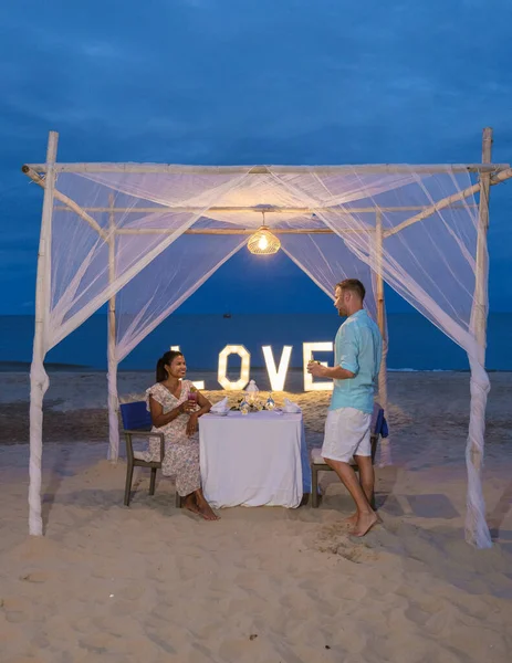 ホアヒンタイのビーチでロマンチックなディナー ホアヒン バレンタインのコンセプトでキャンドルライトによるディナー タイのビーチでロマンチックなディナーをしている男女のカップル — ストック写真