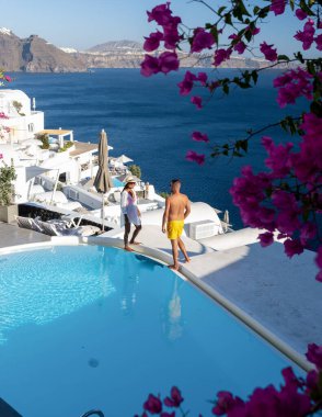 Santorini Yunanistan 'da tatilde, iki erkek ve kadın beyaz boyalı binalarla Oia Santorini' yi ziyaret ediyorlar. Santorini Yunanistan 'da güneşin doğuşunu izleyen genç çift