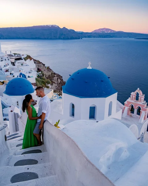 在希腊圣托里尼度假时 两名男子和妇女带着粉刷过的建筑参观了Oia Santorini 在希腊圣托里尼观看日出的年轻夫妇 — 图库照片