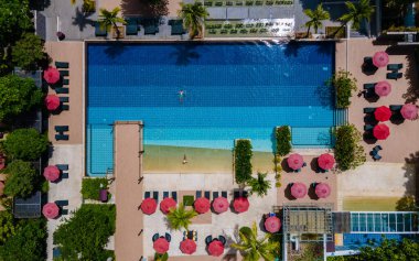 Havuzun yukarısından hava manzarası, yukarıdan drone ile tropikal yüzme havuzu. Erkekler ve kadınlar balayı sırasında lüks bir havuzda dinleniyorlar.