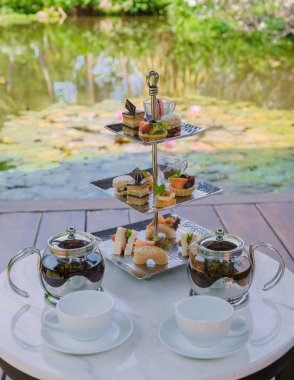 Bir su birikintisinde ikindi çayı, Tayland 'da tropikal bir bahçede çay.. 