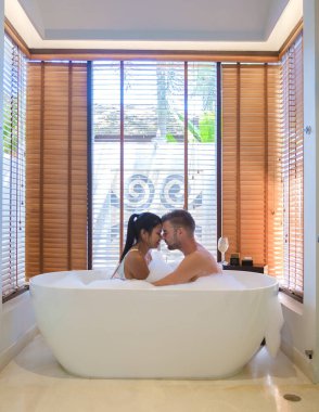 Banyodaki birkaç erkek ve kadın, banyodaki beyaz küvetteki erkekler ve kadınlar.. 