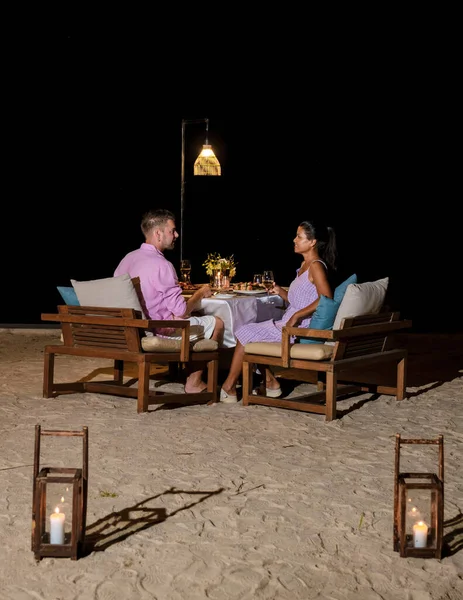 남녀가 저녁에 해변에서 로맨틱 식사를 있습니다 아시아 여자들 코카서스 남자들 — 스톡 사진