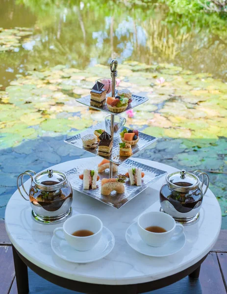 Afternoon tea at a water pond, high tea in a tropical garden in Thailand.