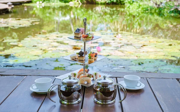 Afternoon tea at a water pond, high tea in a tropical garden in Thailand.