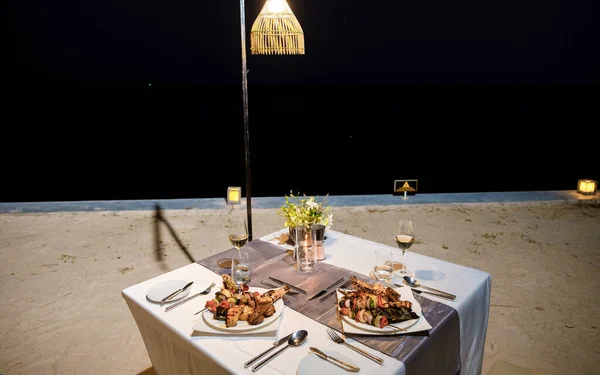 Luxury dinner table by the ocean with lobster, fish, and Thai food.