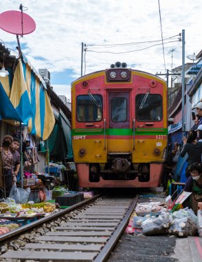 Maeklong Demiryolu Tayland Pazarı. Tren raylarda yavaş ilerliyor. Güneşli bir günde Umbrella Tren Pisti, Mae Klong Tren İstasyonu, Bangkok, Tayland 'da Taze Pazar