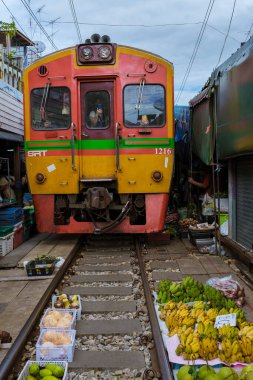 Maeklong Demiryolu Tayland Pazarı. Tren raylarda yavaş ilerliyor. Güneşli bir günde Umbrella Tren Pisti, Mae Klong Tren İstasyonu, Bangkok, Tayland 'da Taze Pazar