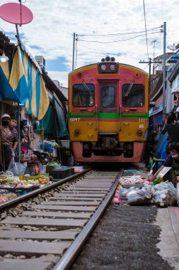 Maeklong Demiryolu Tayland Pazarı. Tren raylarda yavaş ilerliyor. Güneşli bir günde Umbrella Tren Pisti, Mae Klong Tren İstasyonu, Bangkok, Tayland 'da Taze Pazar