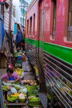 Maeklong Demiryolu Tayland Pazarı. Tren raylarda yavaş ilerliyor. Güneşli bir günde Umbrella Tren Pisti, Mae Klong Tren İstasyonu, Bangkok, Tayland 'da Taze Pazar