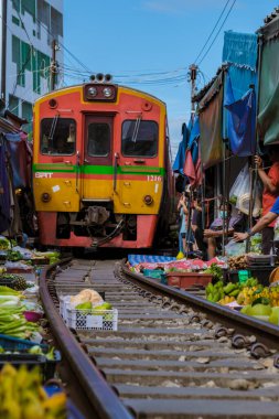 Maeklong Demiryolu Tayland Pazarı. Tren raylarda yavaş ilerliyor. Güneşli bir günde Umbrella Tren Pisti, Mae Klong Tren İstasyonu, Bangkok, Tayland 'da Taze Pazar