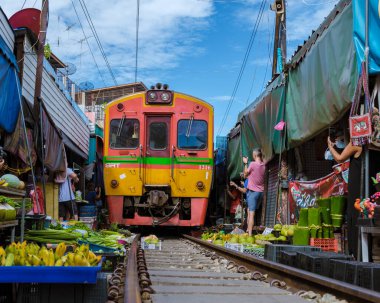 Maeklong Demiryolu Tayland Pazarı. Tren raylarda yavaş ilerliyor. Güneşli bir günde Umbrella Tren Pisti, Mae Klong Tren İstasyonu, Bangkok, Tayland 'da Taze Pazar