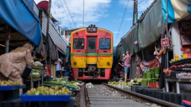 Maeklong Demiryolu Tayland Pazarı. Tren raylarda yavaş ilerliyor. Güneşli bir günde Umbrella Tren Pisti, Mae Klong Tren İstasyonu, Bangkok, Tayland 'da Taze Pazar