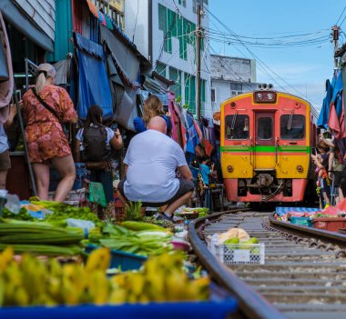 Maeklong Demiryolu Tayland Pazarı. Tren raylarda yavaş ilerliyor. Güneşli bir günde Umbrella Tren Pisti, Mae Klong Tren İstasyonu, Bangkok, Tayland 'da Taze Pazar