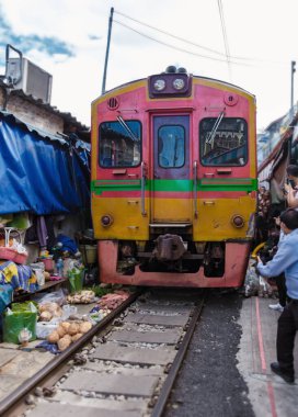 Maeklong Demiryolu Tayland Pazarı. Tren raylarda yavaş ilerliyor. Güneşli bir günde Umbrella Tren Pisti, Mae Klong Tren İstasyonu, Bangkok, Tayland 'da Taze Pazar