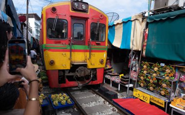 Maeklong Demiryolu Tayland Pazarı. Tren raylarda yavaş ilerliyor. Güneşli bir günde Umbrella Tren Pisti, Mae Klong Tren İstasyonu, Bangkok, Tayland 'da Taze Pazar