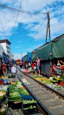Maeklong Demiryolu Tayland Pazarı. Tren raylarda yavaş ilerliyor. Güneşli bir günde Umbrella Tren Pisti, Mae Klong Tren İstasyonu, Bangkok, Tayland 'da Taze Pazar