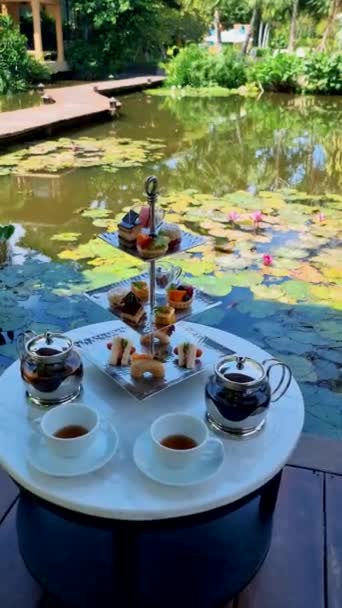 在泰国的一个水塘边喝下午茶 在一个热带花园里喝高茶 — 图库视频影像