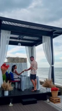 Huahin Tayland sahilinde romantik bir akşam yemeği Hua Hin 'de mum ışığında akşam yemeği, sevgililer günü konsepti. Tayland sahilinde romantik bir akşam yemeği yiyen iki erkek ve kadın. 