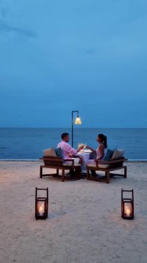 Huahin Tayland sahilinde romantik bir akşam yemeği Hua Hin 'de mum ışığında akşam yemeği, sevgililer günü konsepti. Tayland sahilinde romantik bir akşam yemeği yiyen iki erkek ve kadın. 