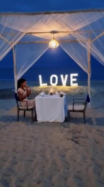 Huahin Tayland sahilinde romantik bir akşam yemeği Hua Hin 'de mum ışığında akşam yemeği, sevgililer günü konsepti. Tayland sahilinde romantik bir akşam yemeği yiyen iki erkek ve kadın. 