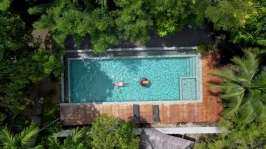 Krabi Tayland 'ın ormanında yüzme havuzunun hava aracı görüntüsü, Tayland ormanında yüzme havuzunun üstünde insansız hava aracı. Havuzdaki çift erkek ve kadın yukarıdan
