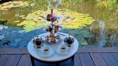 Bir su birikintisinde ikindi çayı, Tayland 'da tropikal bir bahçede çay.. 