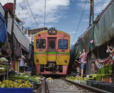 Maeklong Demiryolu Tayland Pazarı. Tren raylarda yavaş ilerliyor. Güneşli bir günde Umbrella Tren Pisti, Mae Klong Tren İstasyonu, Bangkok, Tayland 'da Taze Pazar