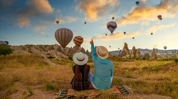 カパドキヤ カッパドキア トルコは カパドキヤ カッパドキア トルコの熱気球を見ている日の出の間に幸せな若いカップルです トルコでの休暇中のアジアの女性と白人男性 — ストック写真