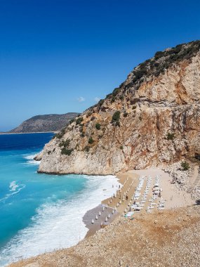 Kaputas plajı Lycia sahili Türkiye Kaputas Sahili, Akdeniz, Kas, Türkiye. Plaj yatağı ve şemsiyelerle yaz boyunca güneşli bir gün.