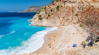 Kaputas plajı Lycia sahili Türkiye Kaputas Sahili, Akdeniz, Kas, Türkiye. Plaj yatağı ve şemsiyelerle yaz boyunca güneşli bir gün.