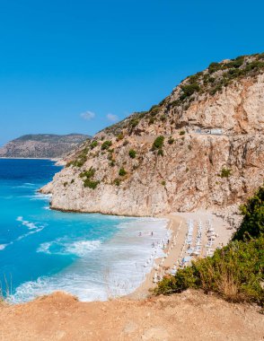 Kaputas plajı Lycia sahili Türkiye Kaputas Sahili, Akdeniz, Kas, Türkiye. Plaj yatağı ve şemsiyelerle yaz boyunca güneşli bir gün.