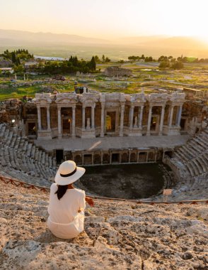 Hierapolis antik kenti Pamukkale Türkiye, Unesco 'nun kalıntıları, Hierapolis antik kenti Pamukkale Türkiye Hierapolis' te günbatımını izleyen şapkalı genç Asyalı kadınlar