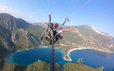 Fethiye 'de paragliding in Fethiye, Turkey Paraglider uçuyor gün batımında Oludeniz plajı üzerinde.