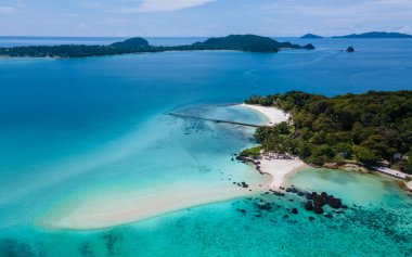 Kristal berraklığında okyanusu olan tropik bir ada, Koh Kham Trat Tayland, Koh Mak Tayland yakınlarındaki tropik adanın havadan görünüşü. Beyaz kumlu sahil, palmiye ağaçları ve okyanusta büyük siyah kaya taşları.