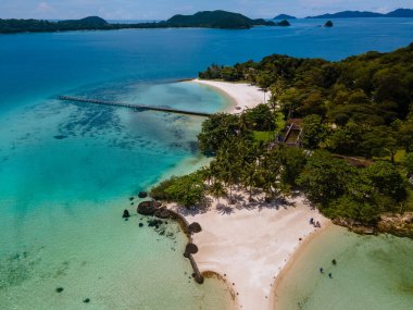 Tropik ada Koh Kham Trat Tayland, Koh Mak Tayland yakınlarındaki tropik adanın havadan görünüşü. Beyaz kumlu sahil, palmiye ağaçları ve okyanusta büyük siyah kaya taşları.