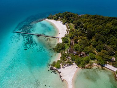 Kristal berraklığında okyanusu olan tropik bir ada, Koh Kham Trat Tayland, Koh Mak Tayland yakınlarındaki tropik adanın havadan görünüşü. Beyaz kumlu sahil, palmiye ağaçları ve okyanusta büyük siyah kaya taşları.
