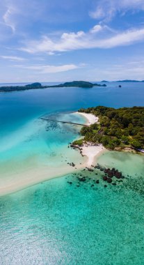 Kristal berraklığında okyanusu olan tropik bir ada, Koh Kham Trat Tayland, Koh Mak Tayland yakınlarındaki tropik adanın havadan görünüşü. Beyaz kumlu sahil, palmiye ağaçları ve okyanusta büyük siyah kaya taşları.