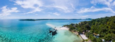 Kristal berraklığında okyanusu olan tropik bir ada, Koh Kham Trat Tayland, Koh Mak Tayland yakınlarındaki tropik adanın havadan görünüşü. Beyaz kumlu sahil, palmiye ağaçları ve okyanusta büyük siyah kaya taşları.