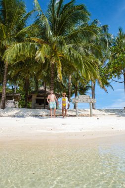 Koh Mak Tayland yakınlarındaki Koh Kham Trat adasında, Tayland 'da tropik bir plajda yürüyen bir çift. Koh Kham Adası 'nda palmiye ağaçları olan beyaz kumlu plaj.