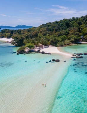 Tayland 'da Koh Kham Adası Trat Koh Mak adlı tropikal bir adada yaşayan bir çift. Beyaz kumlu tropik sahil ve palmiye ağaçlı mavi okyanus