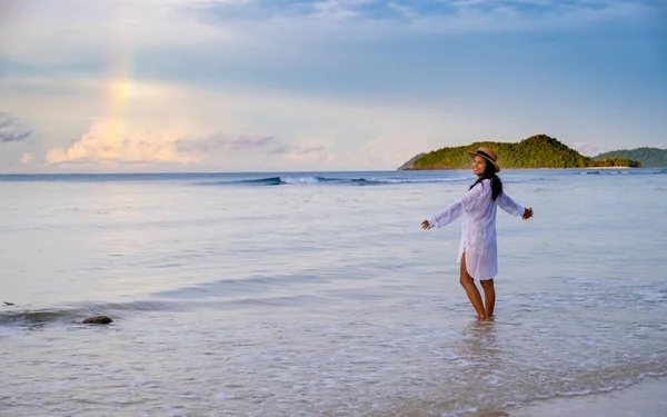 タイのモンスーン性暴風雨の後 ビーチで虹を見るアジアの女性日の出の間 コマックのビーチを歩くアジアの女性 — ストック写真