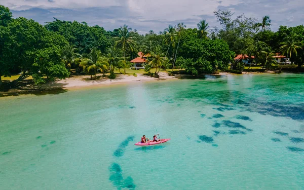 タイのコマック島の熱帯の海にあるカヤックの男性と女性 青い海と白い砂浜にヤシの木があるカヤックの男と女 — ストック写真