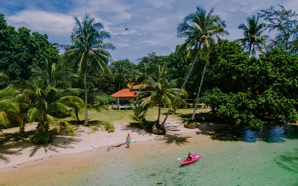 タイのコマック島の熱帯の海にあるカヤックの男性と女性 青い海と白い砂浜にヤシの木があるカヤックの男と女 — ストック写真