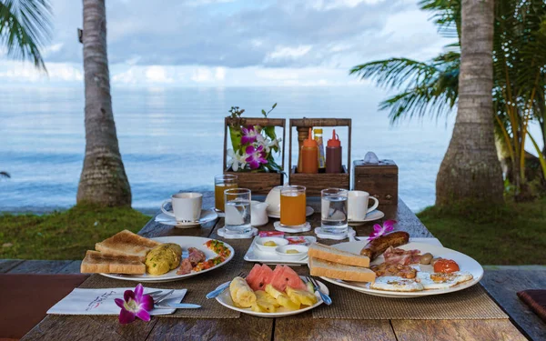タイのヤシの木とビーチでの朝食テーブル 卵と果物でカラフルな朝食 — ストック写真